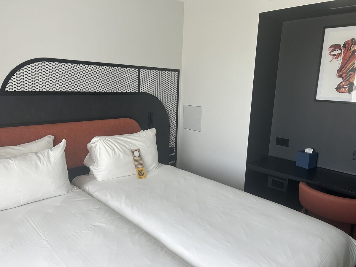 Tribe Hotel room headboard detail with bedside desk and artwork