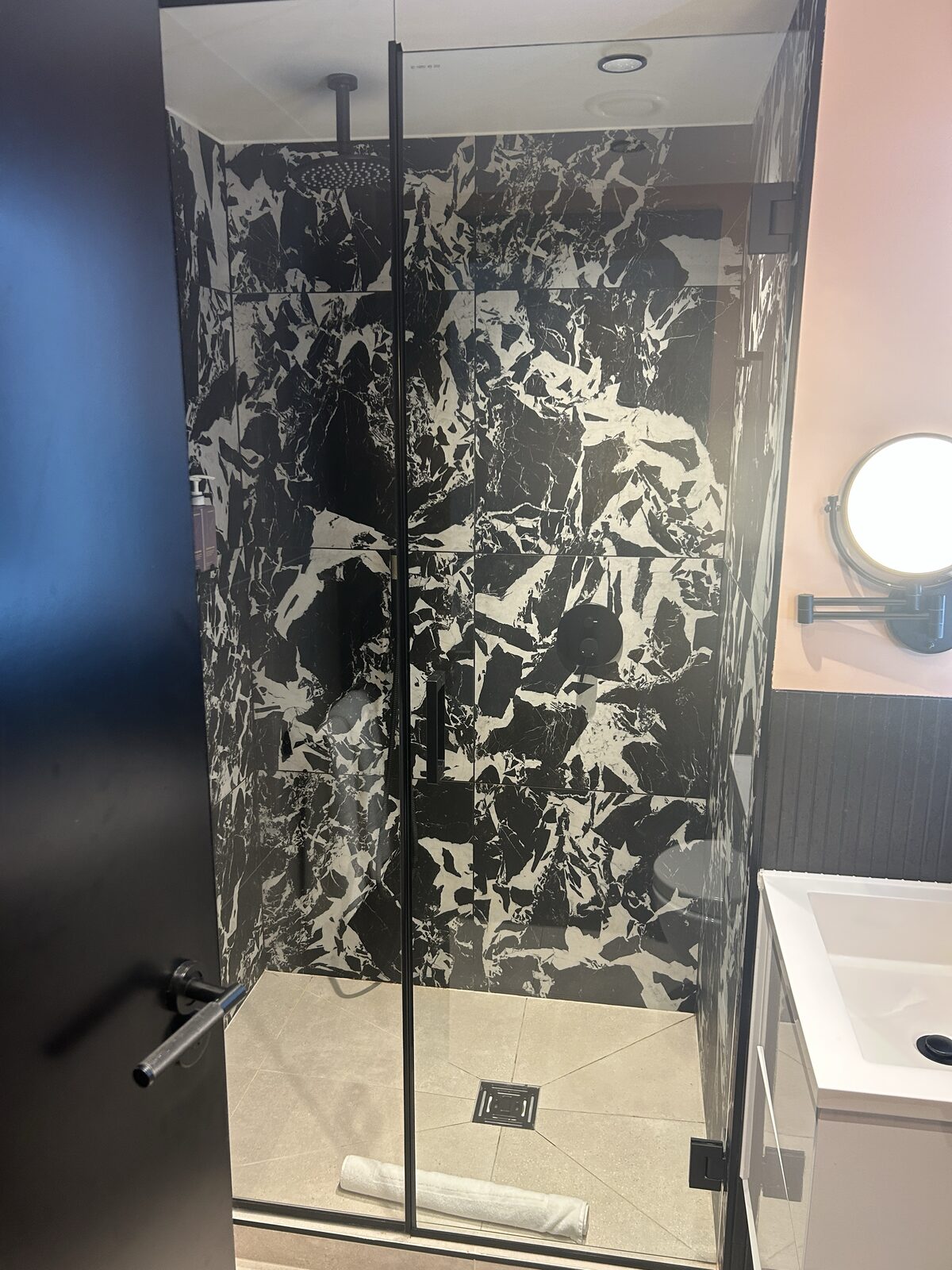 Tribe Hotel walk-in shower with rainfall head and marble-effect tiles